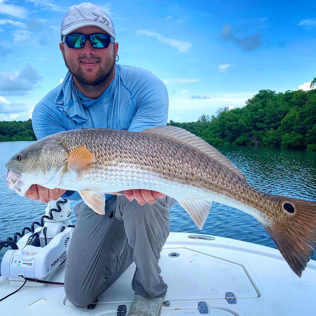 InshoreAction Inshore Charter Capt Matt Luttmann with a solid redfish landed during an inshore charter with InshoreAction Charters.